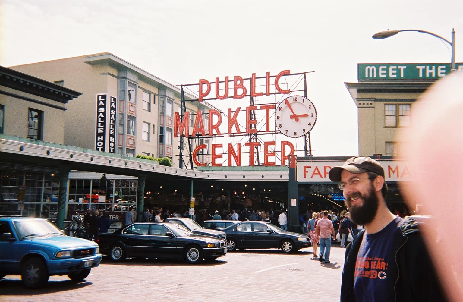 Man with beard smiling in front of Public Market Center Seattle