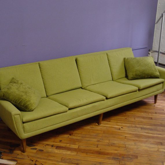 A chartreuse couch against a purple wall