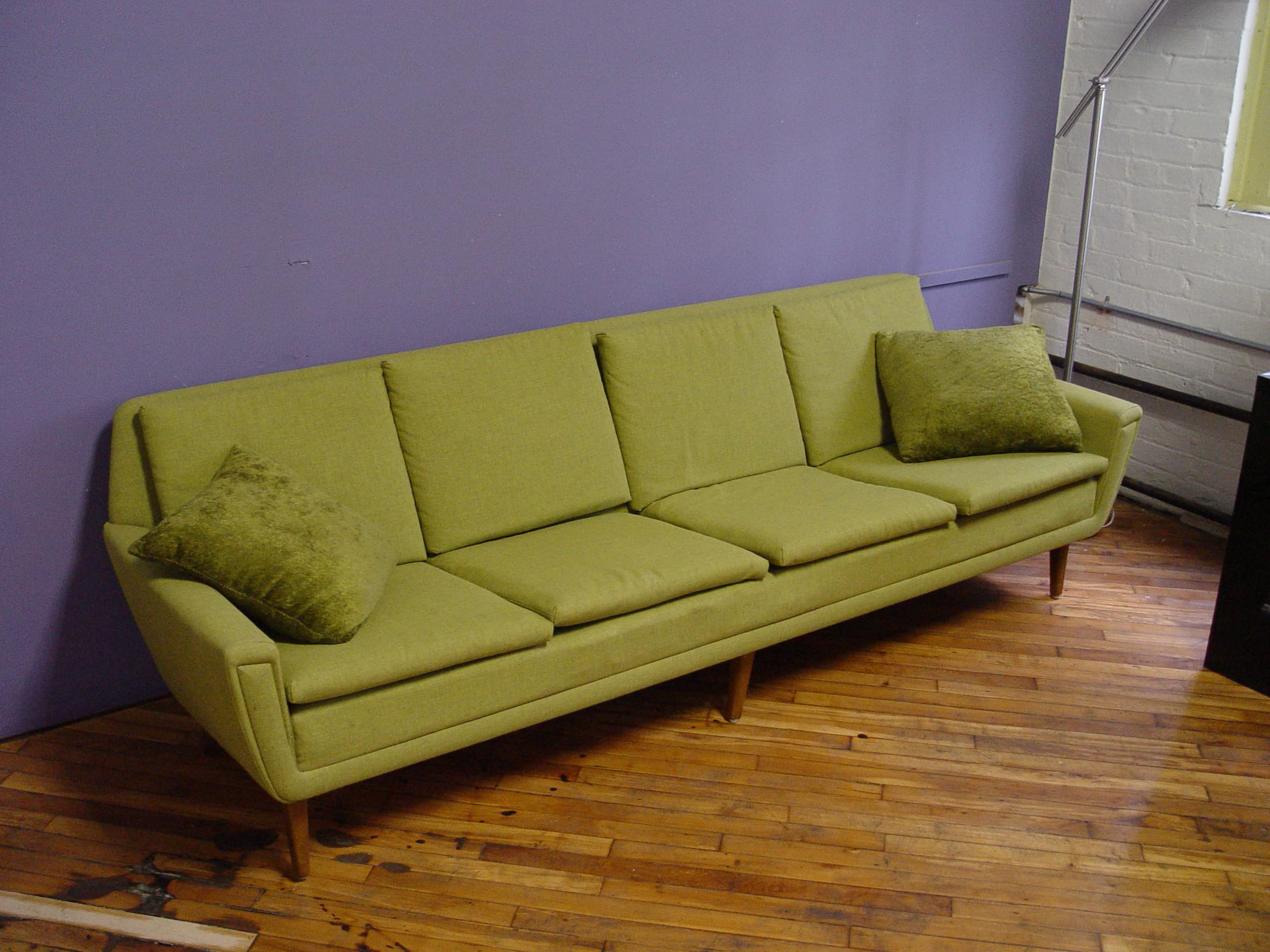 A chartreuse couch against a purple wall