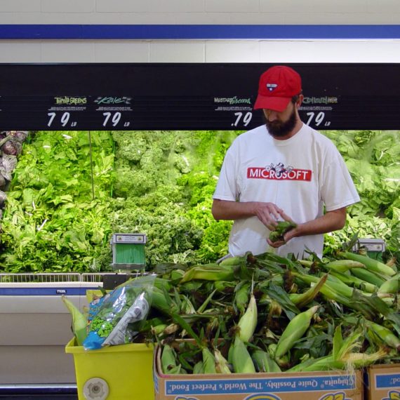 Man selecting corn at a grocery store