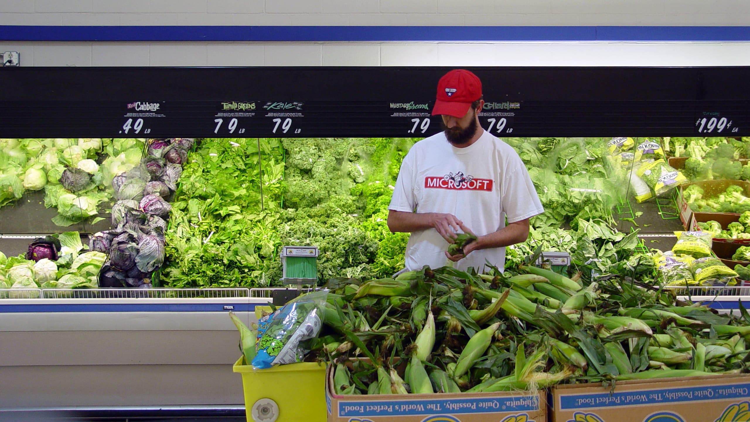 Man selecting corn at a grocery store