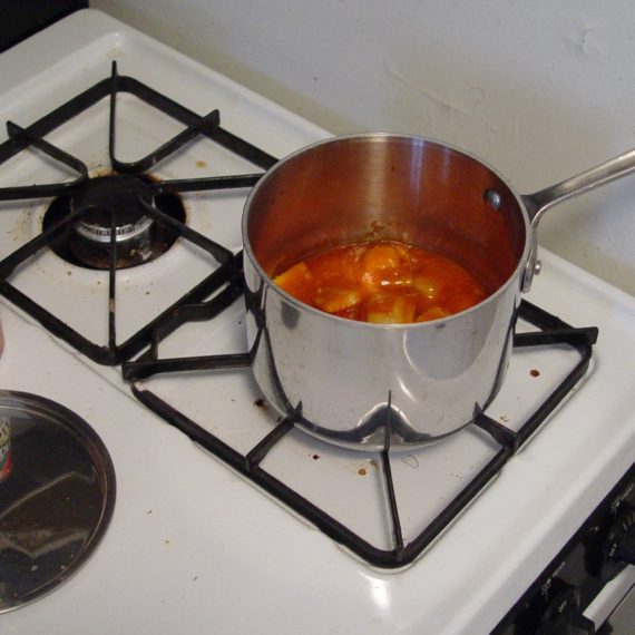 Ravioli in pan next to can on stove