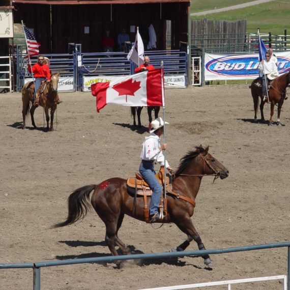 Cowboy rides horse with Canadian flag