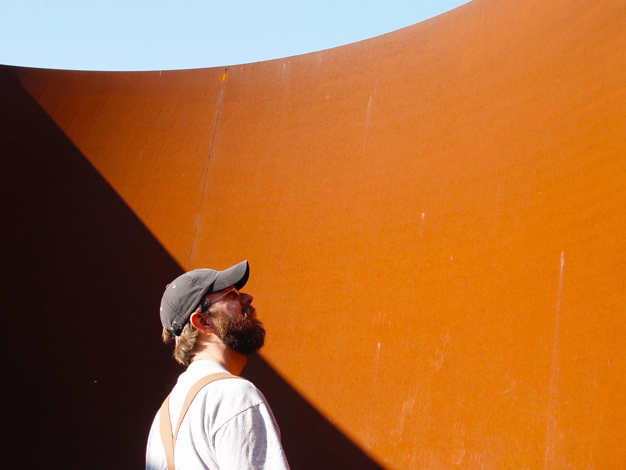 Bearded man in front of Serra sculpture