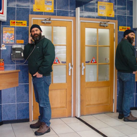 Bearded man at payphone in automat