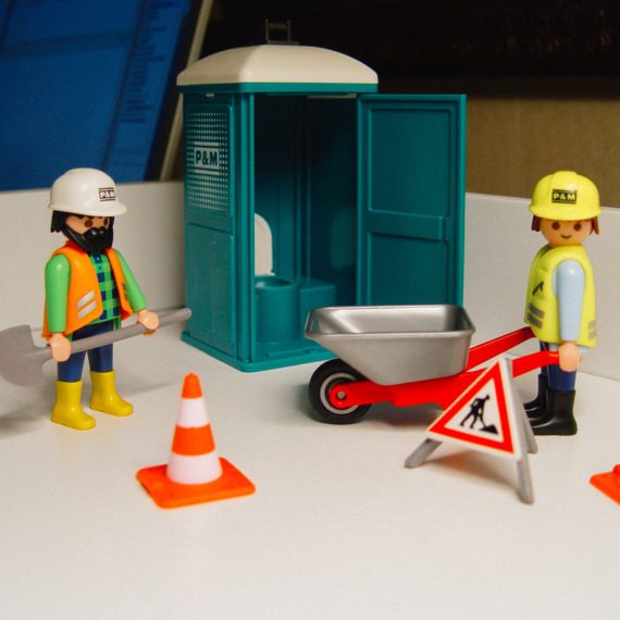 Playmobil construction workers and toy portolet