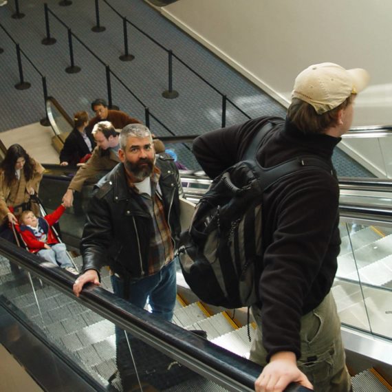 Bearded man rides up escalator