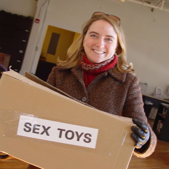 Woman holds box with a label that say SEX TOYS