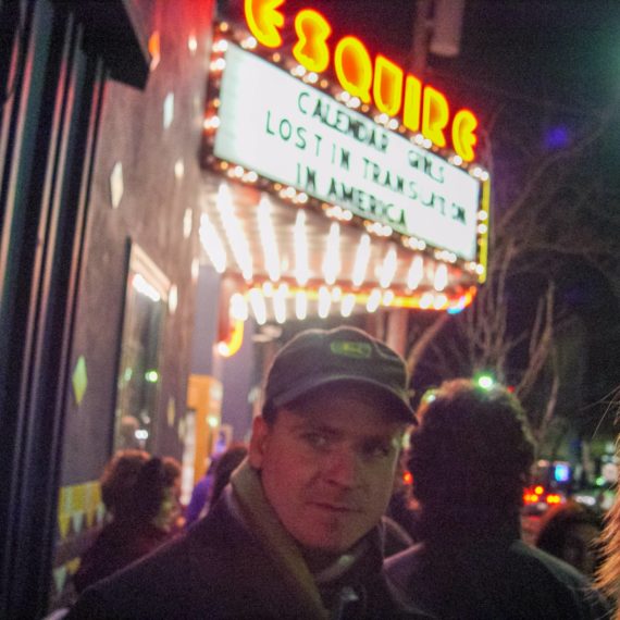 Man in front of movie theater marquee