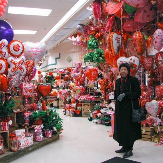 Woman in floral section of grocery decorated for Valentine’s Day