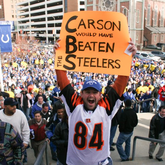 Man holds up sign "Carson would have Beaten the Steelers" outside the RCA Dome in Indianapolis