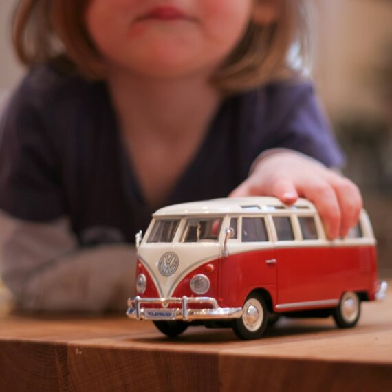 Young person plays with a toy VW Bus