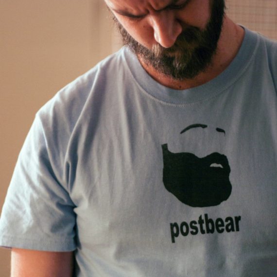 Bearded man wearing t-shirt with silhouetted bearded man and the word 'postbear'