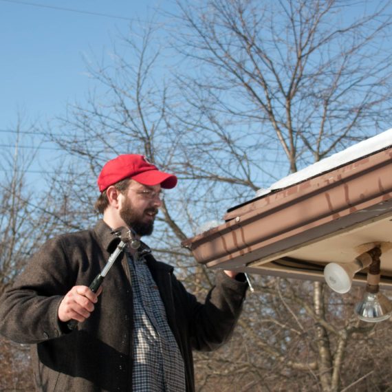 Man chips ice out of gutter