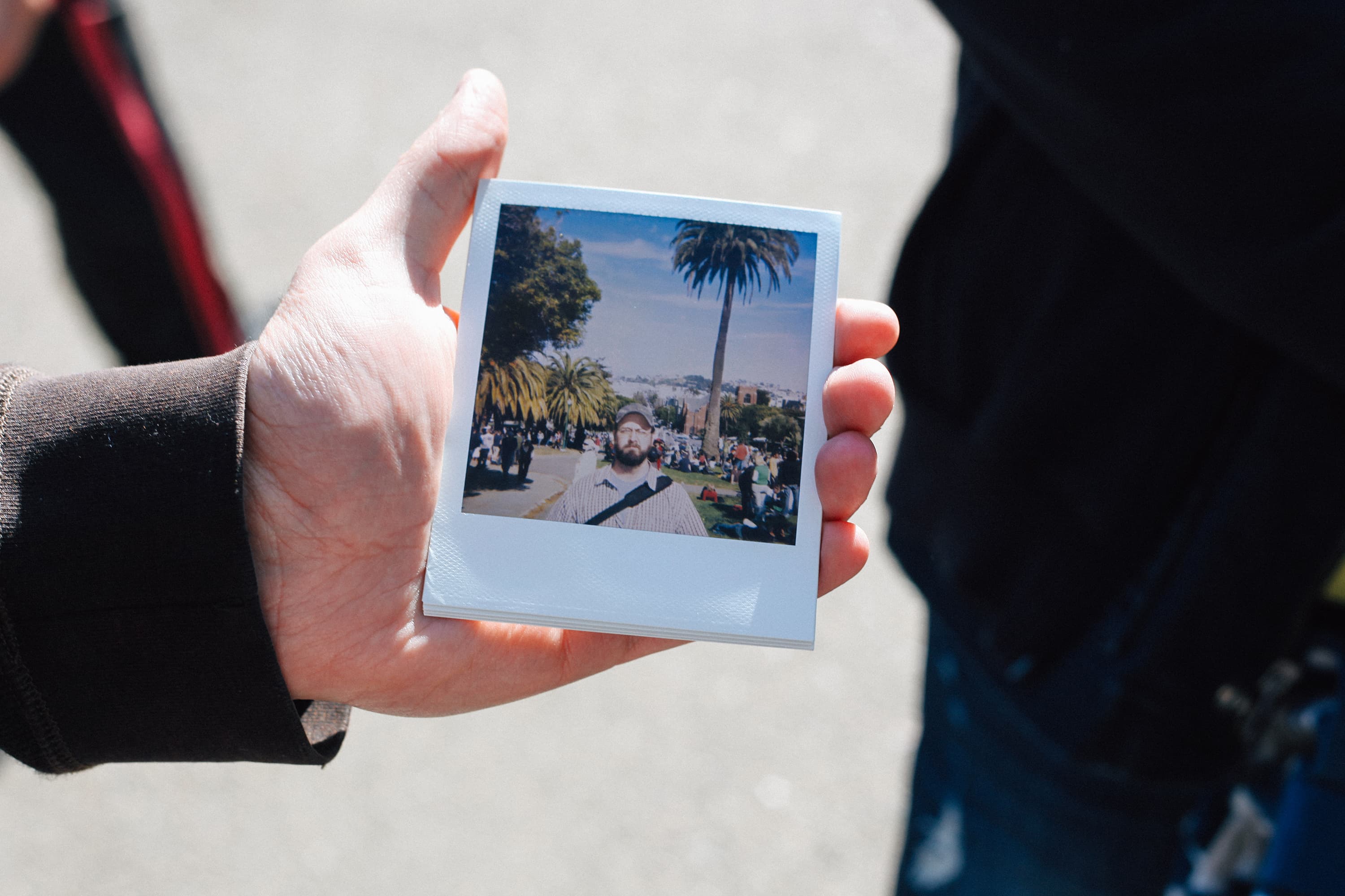 Person holding Polaroid photo of a man in San Francisco