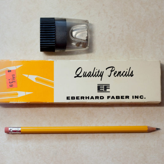 A box of Quality brand pencils, a pencil sharpener, and a pencil