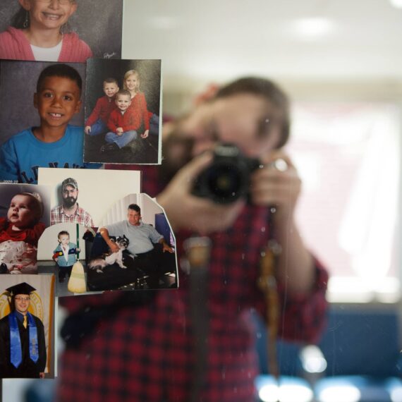 Man takes photos of photos on mirror in barber shop