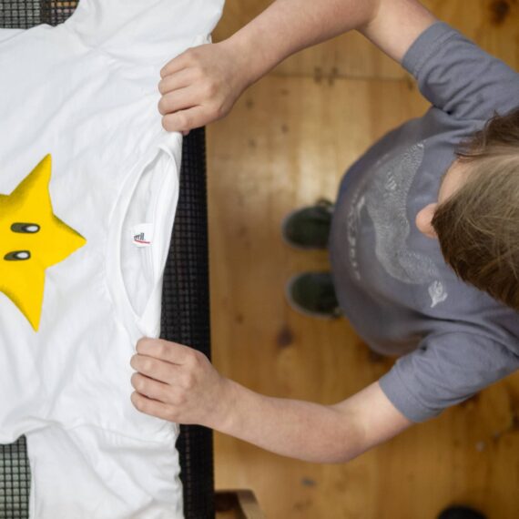 Young person pulls a star shirt from the dryer