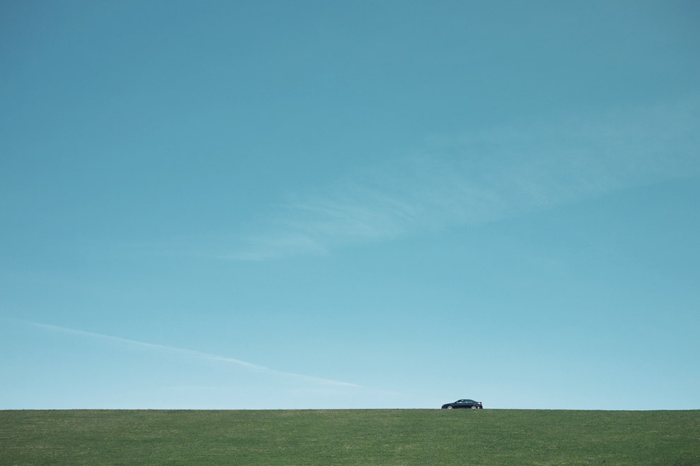 a Ford Edge on top of a green bit of land with a bunch of blue skies above