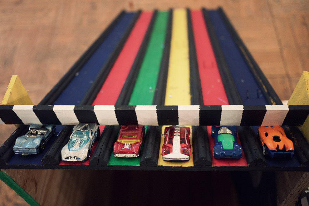 Toy cars about to race down a colorful track