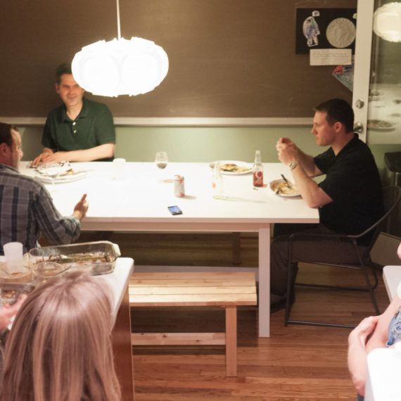 Friends sit around kitchen table and kitchen