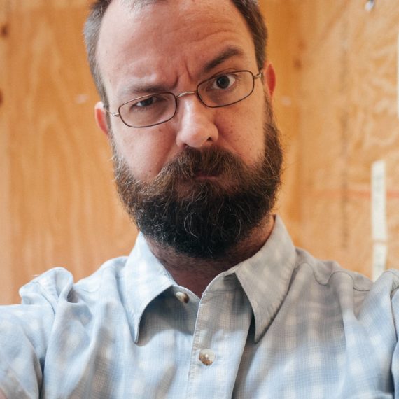 Man with beard and glasses takes selfie