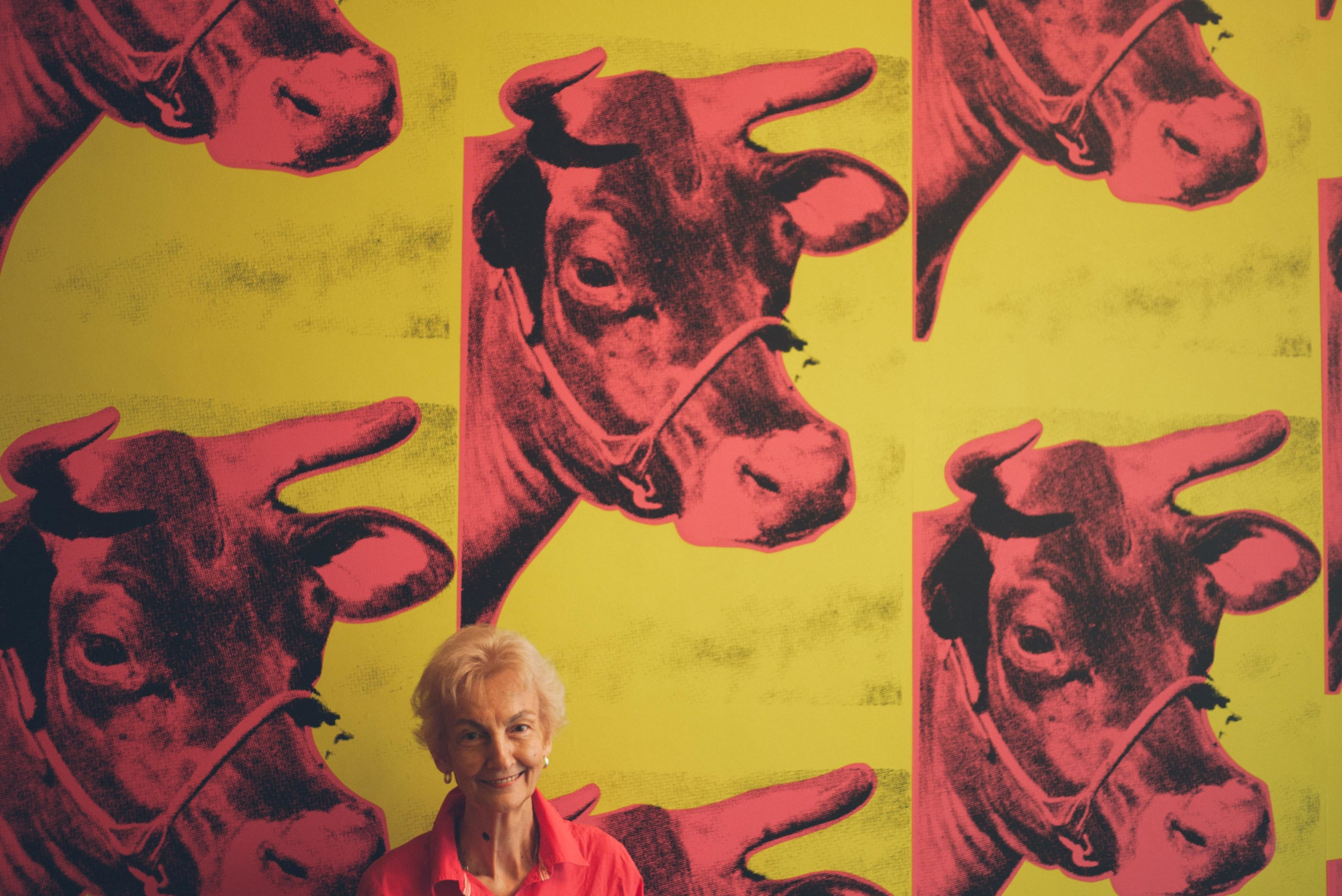 Woman in front of Andy Warhol cow wallpaper