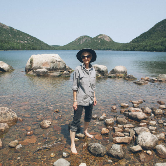 Woman stands on rocks in Jordan Pond, Acadia National Park