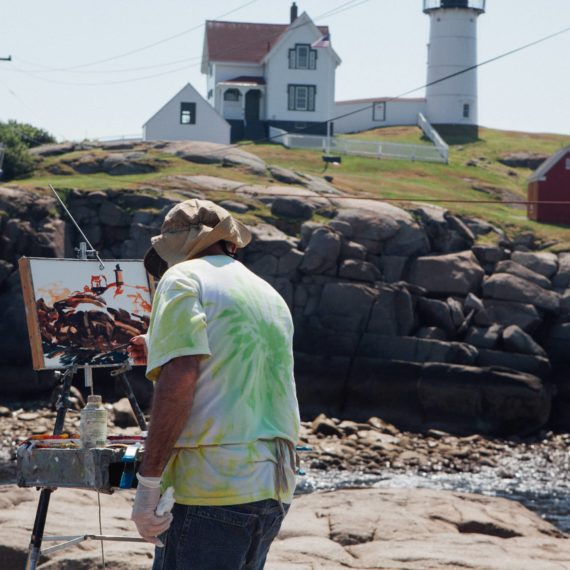 En plein air artist paints a lighthouse