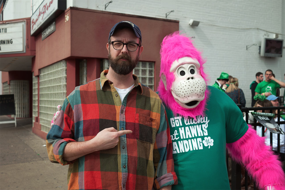 bearded man pointing at person in pink gorilla suit