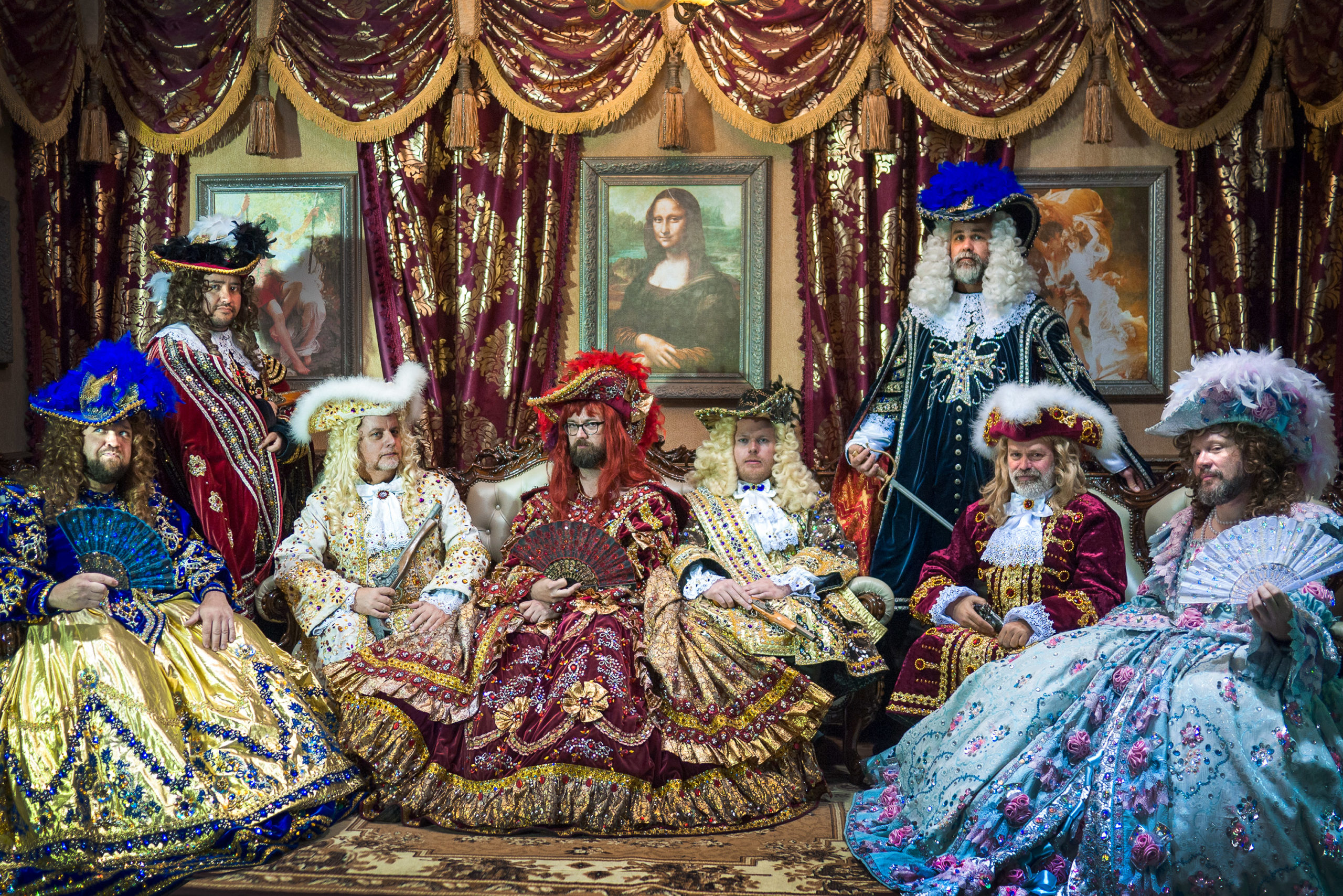 A group of gentlemen in historic garb pose for a tourist photo