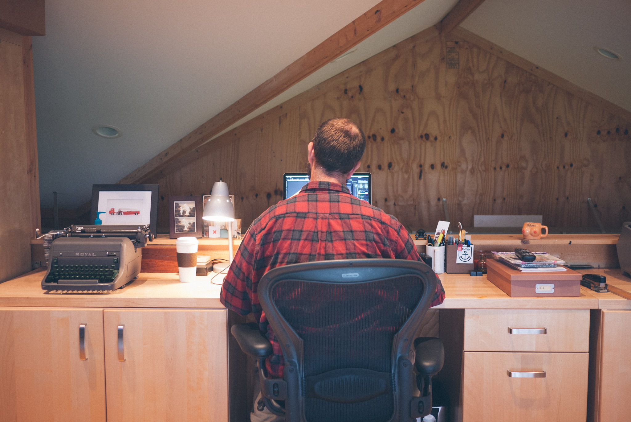 Back of a balding man at a desk