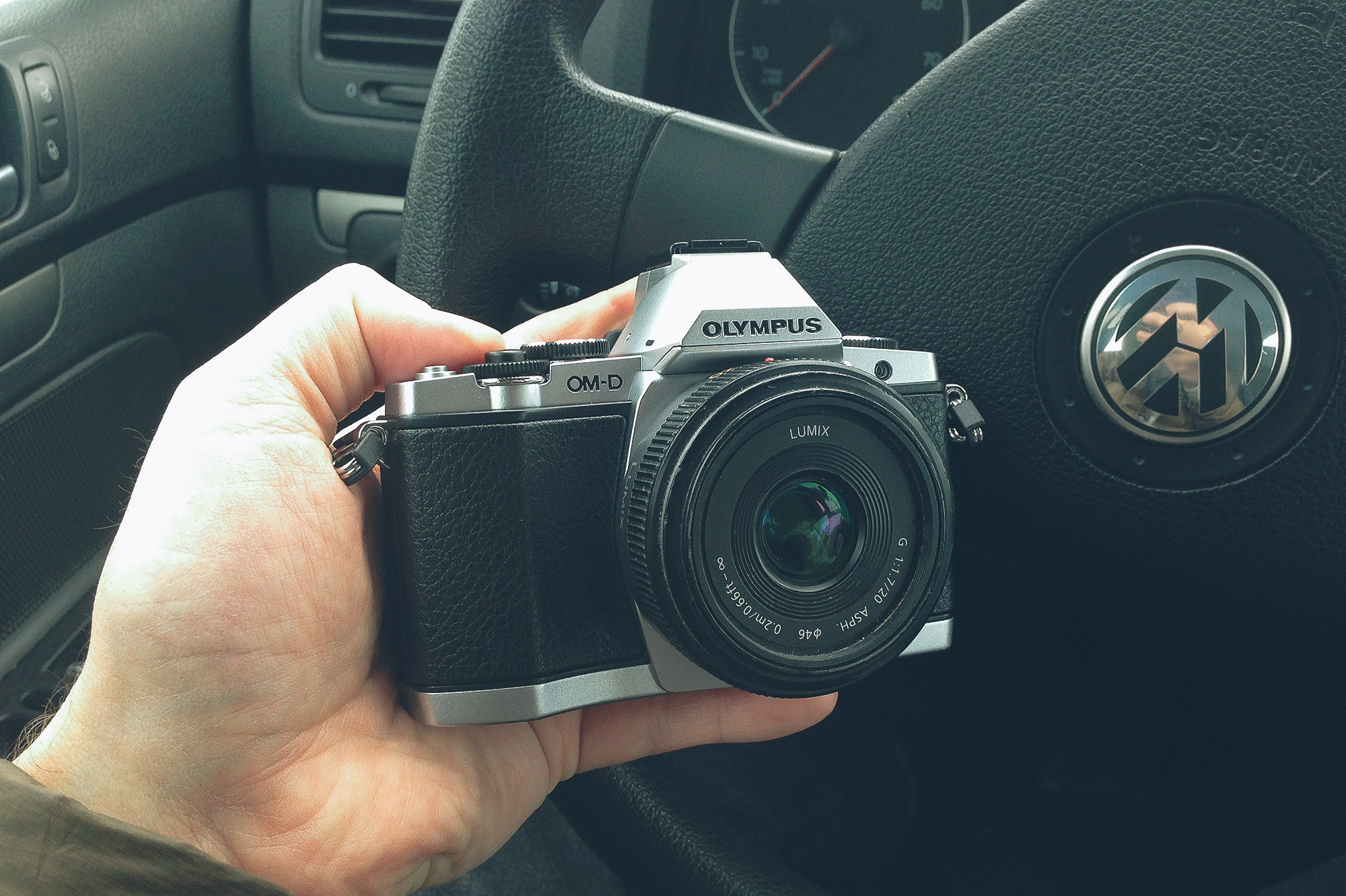 A person holding an Olympus digital camera in the year 2013