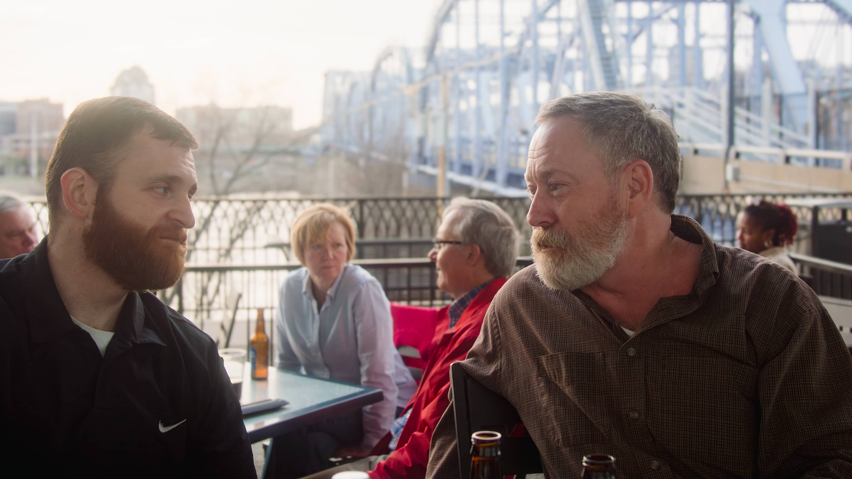 Men regarding each other with the Ohio River as a backdrop