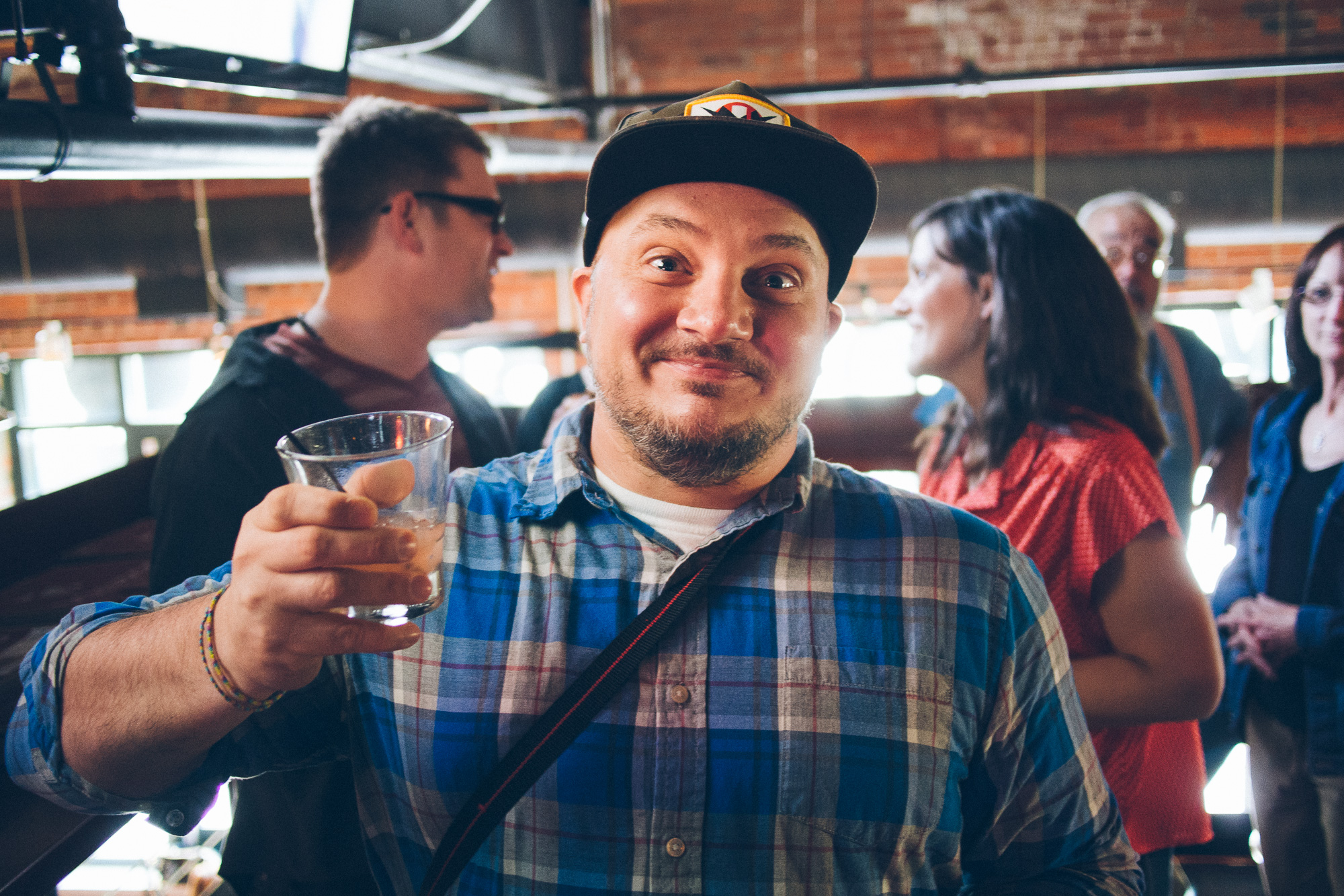 A man smiling, holding a beer