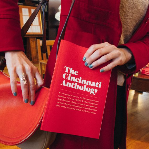 A person holds a book called The Cincinnati Anthology