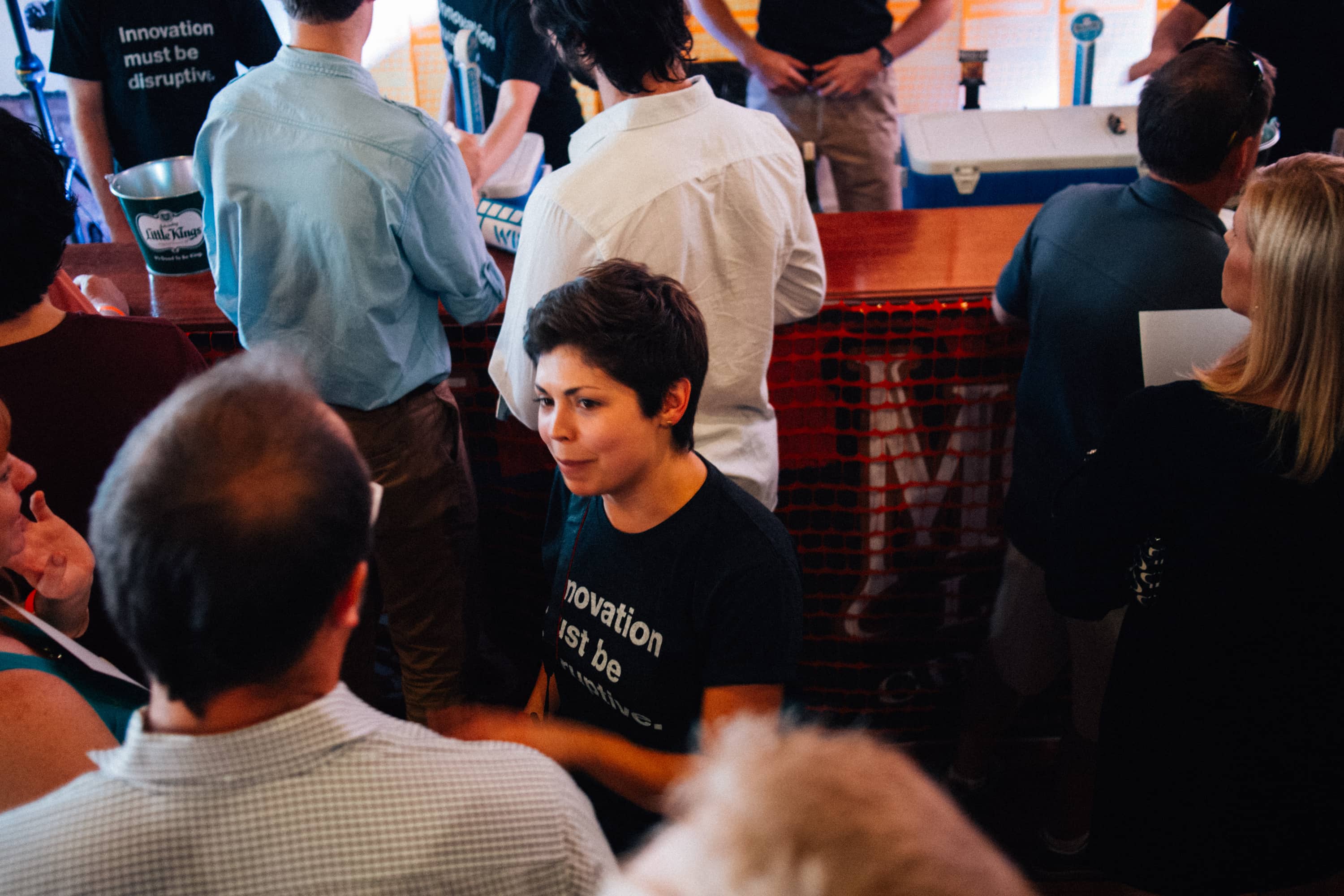 A woman listens intently in a crowded room