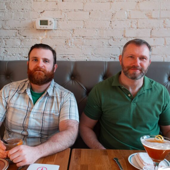 Two bearded men at a restaurant with cocktails