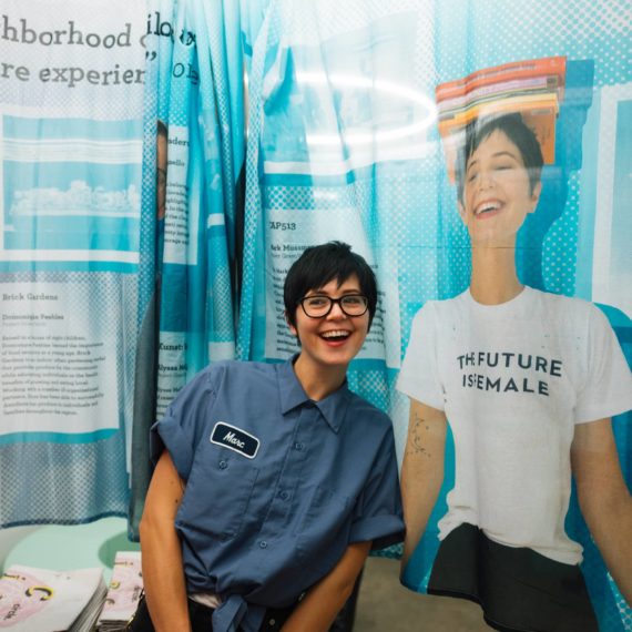 Person poses next to their photograph printed on a sheer curtain