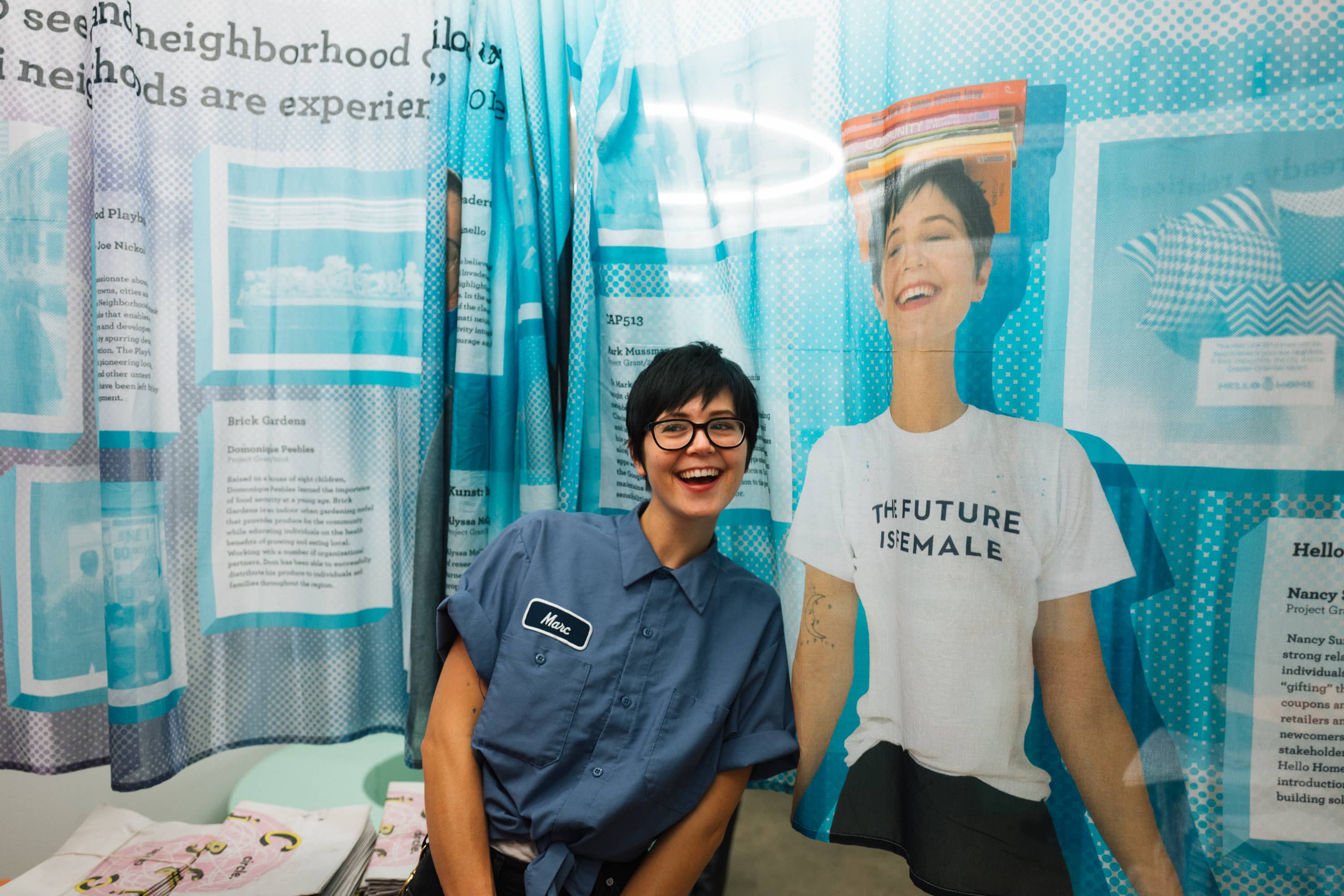 Person poses next to their photograph printed on a sheer curtain