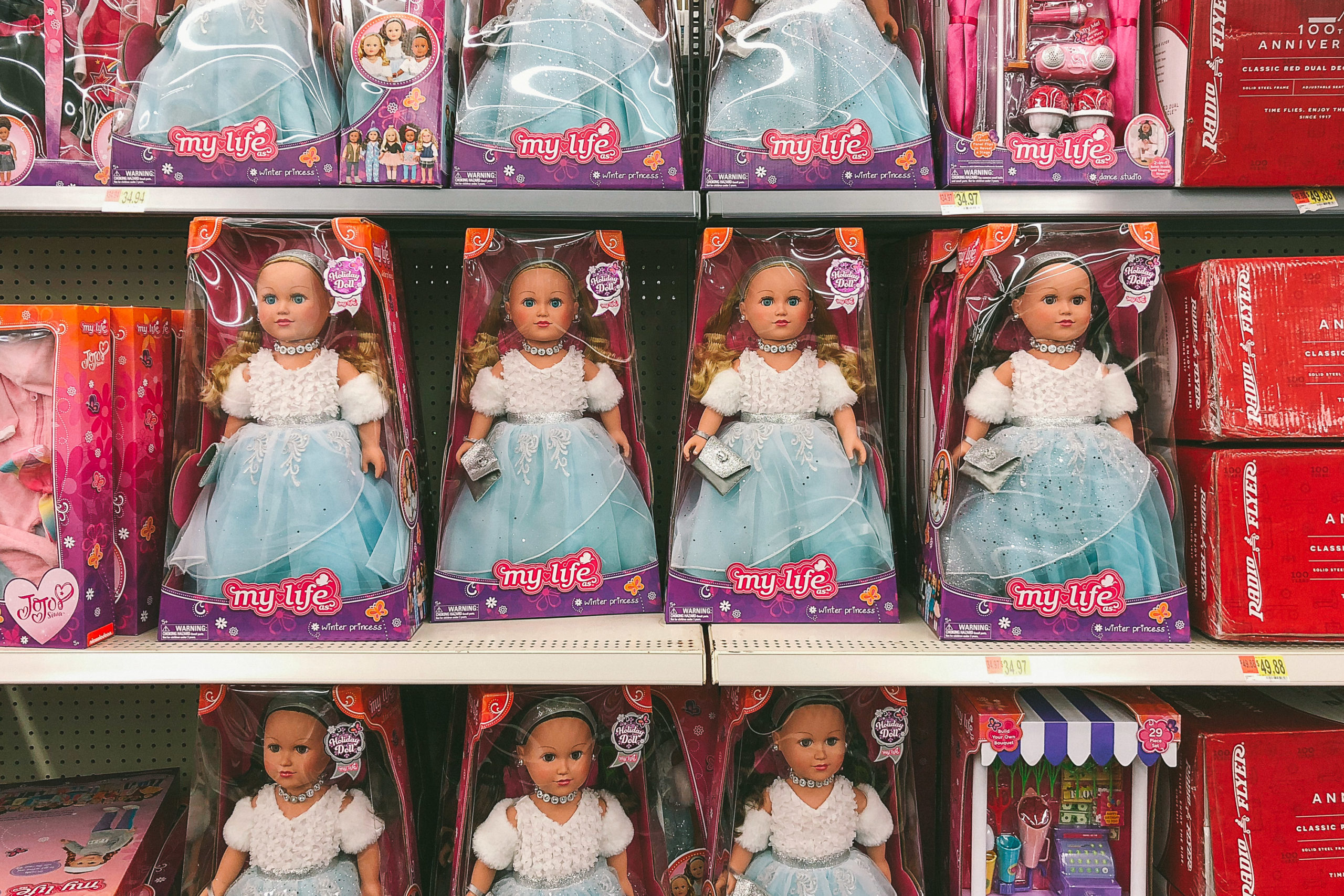 A bunch of dolls in their packaging on an endocarp at Walmart