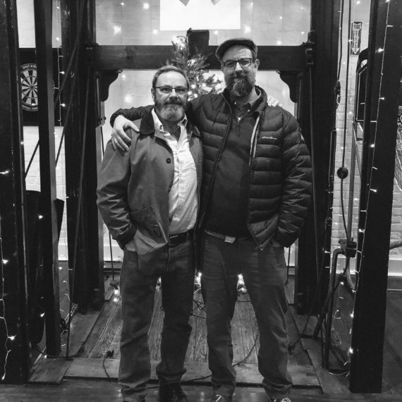 Two men with beards pose for birthday portrait