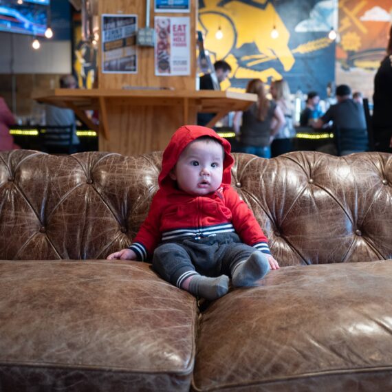 Toddler in red hoody on big couch