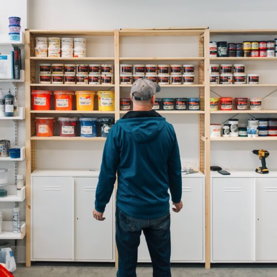 Man looks over shelves for ink and other screen printing supplies