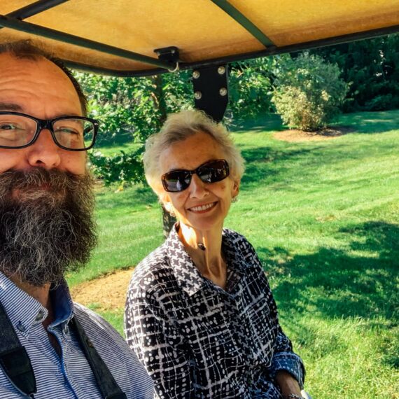 Smiling on a tram in a lush setting