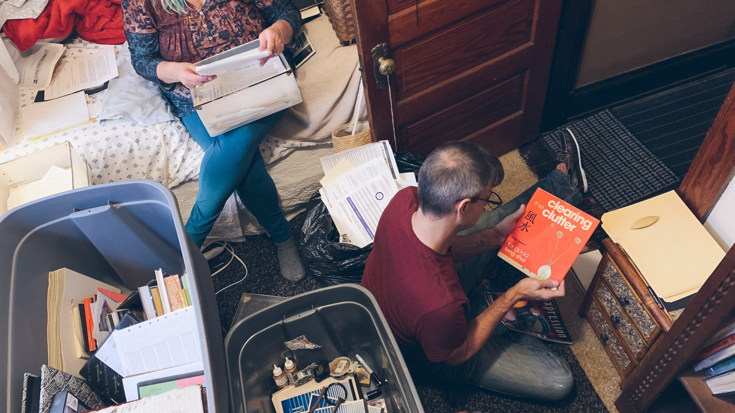 A woman and man sorting through boxes and photographs