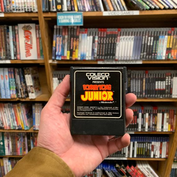 Person holding Donkey Kong Jr. video game cartridge for ColecoVision