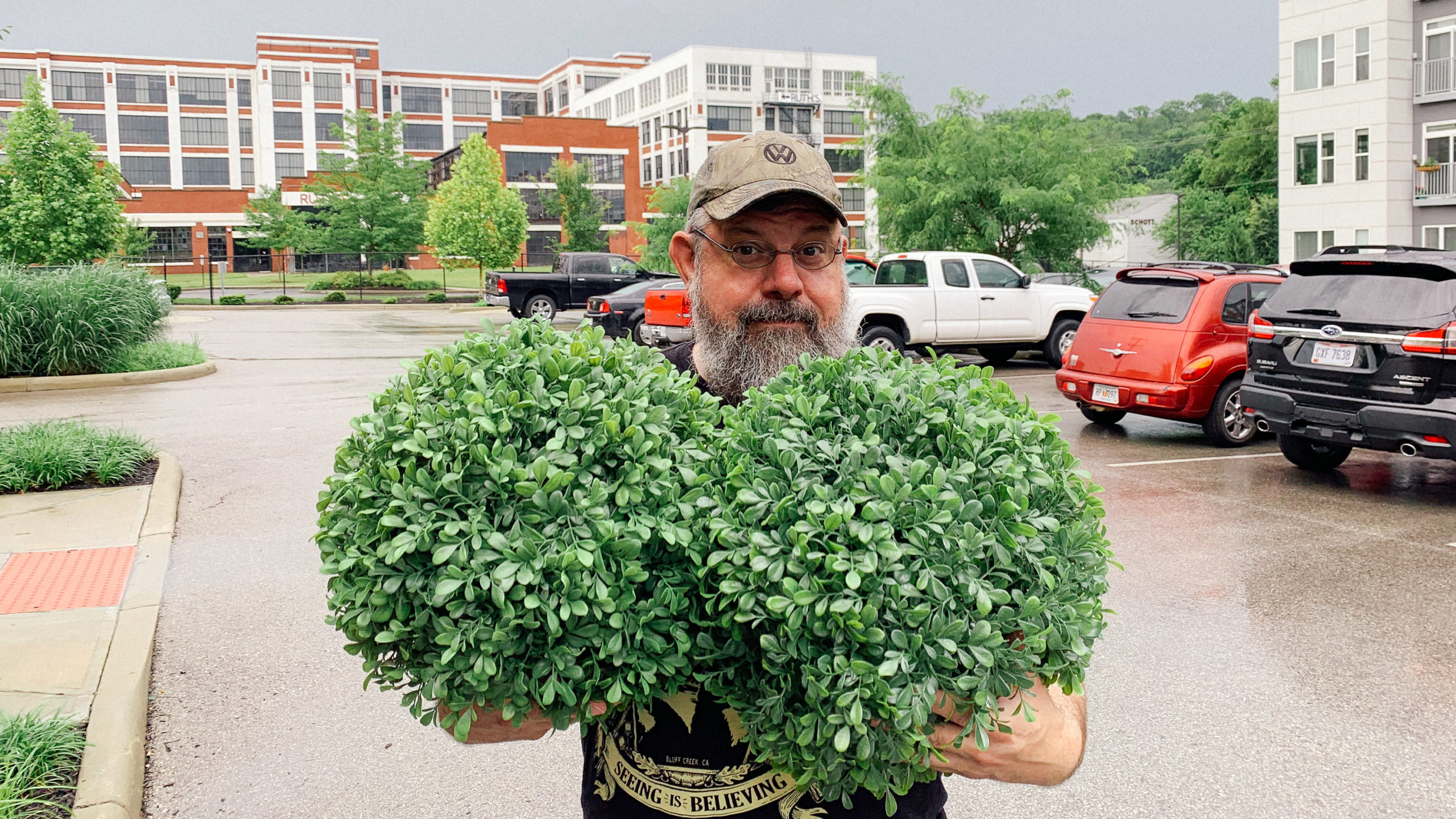 Man holding fake shrubs