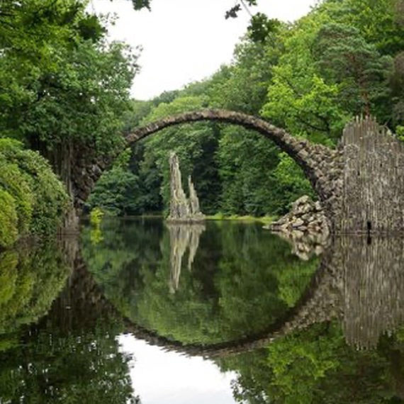 Half circular bridge that looks like a full circle in the reflection of the water