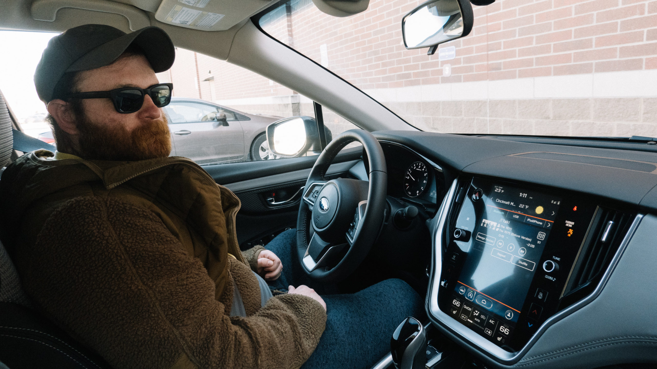 A bearded man behind the wheel of a Subaru Outback